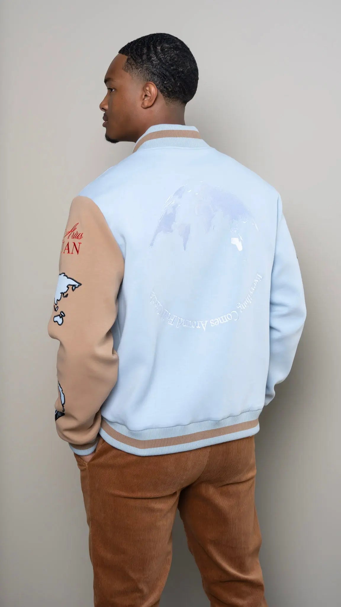 Photo of model in the Arius Juan Sky Blue Worldly Letterman Jacket posing for product picture.