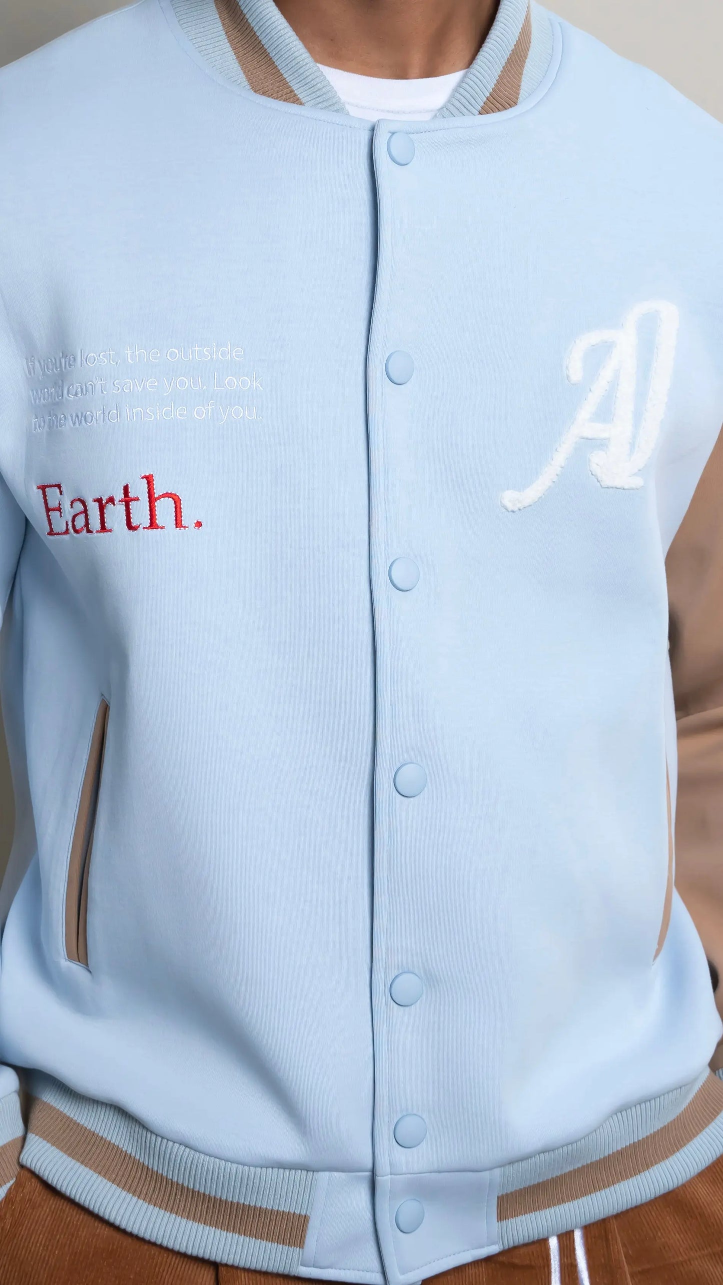 Photo of model in the Arius Juan Sky Blue Worldly Letterman Jacket posing for product picture.