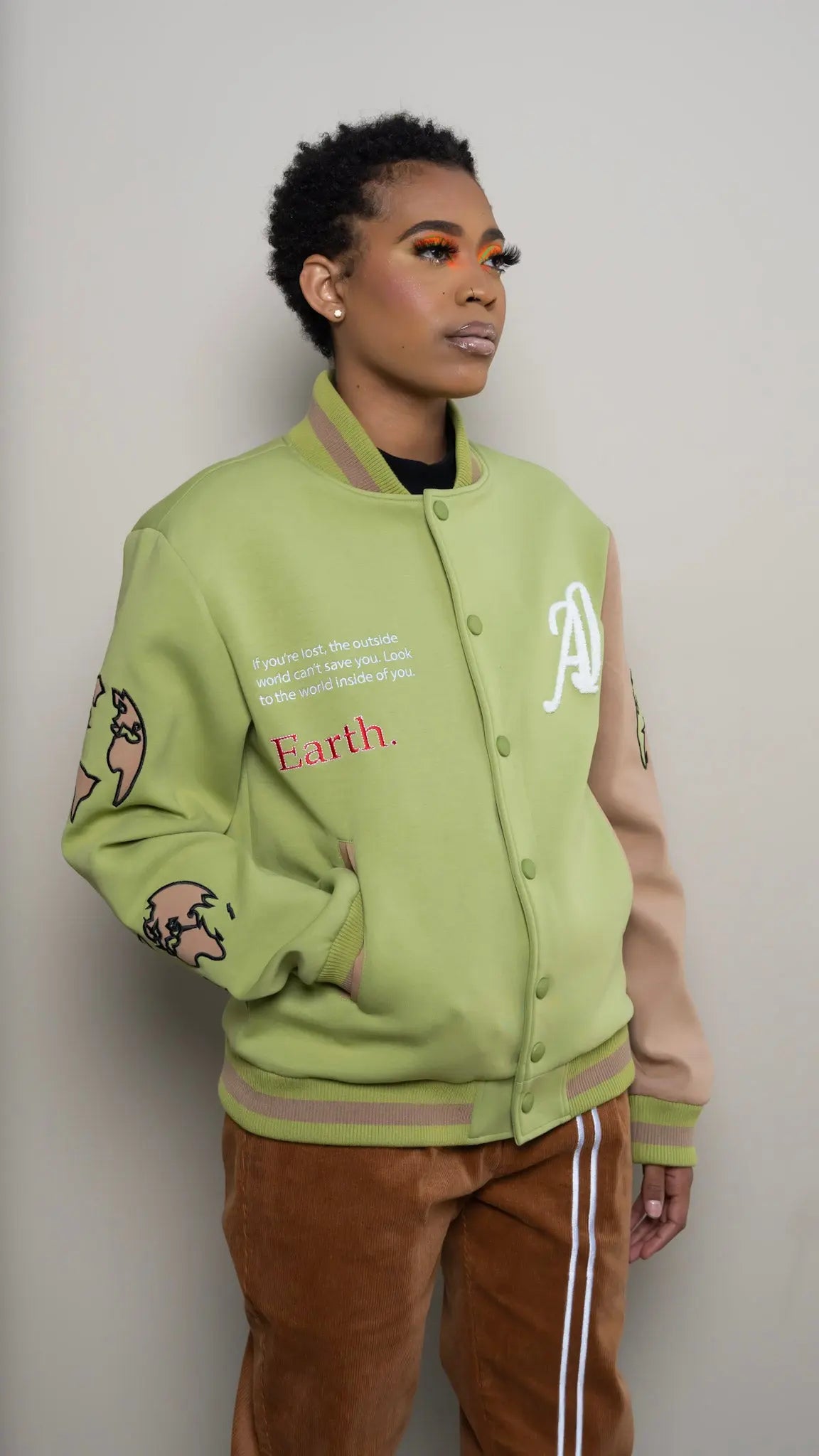 Photo of model in the Arius Juan Olive Green Worldly Letterman Jacket posing for product picture.