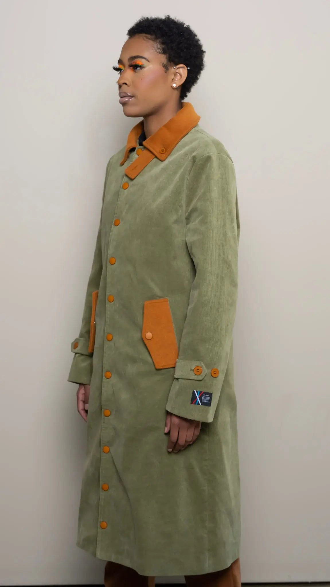 Photo of model in the Arius Juan Olive Green Earthly Trench Coat posing for product picture.