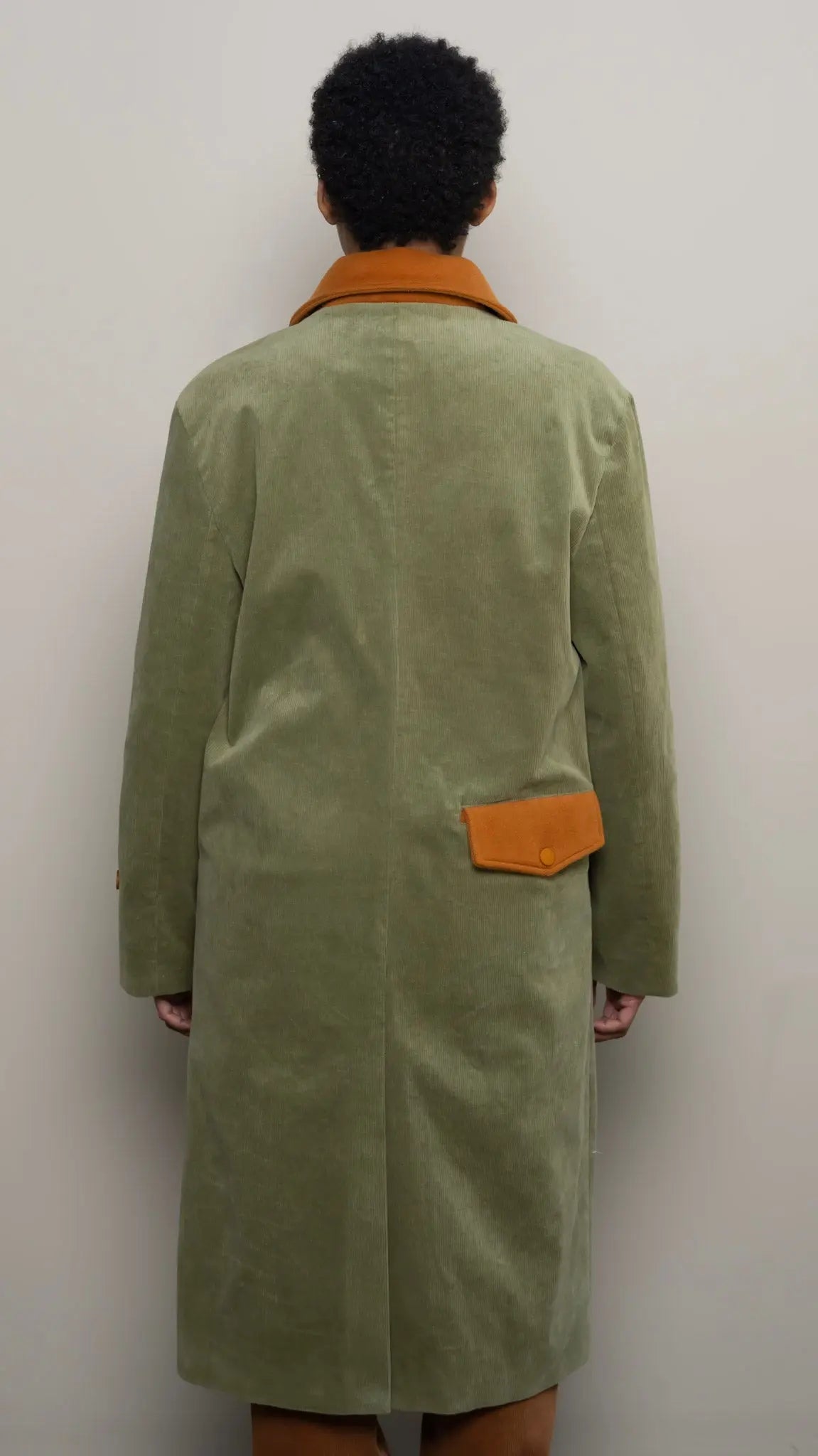 Photo of model in the Arius Juan Olive Green Earthly Trench Coat posing for product picture.