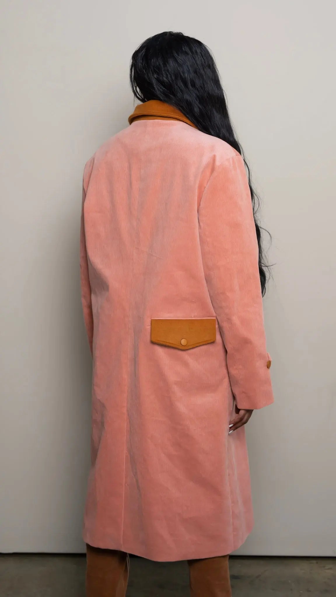 Photo of model in the Arius Juan Salmon Pink Earthly Trench Coat posing for product picture.