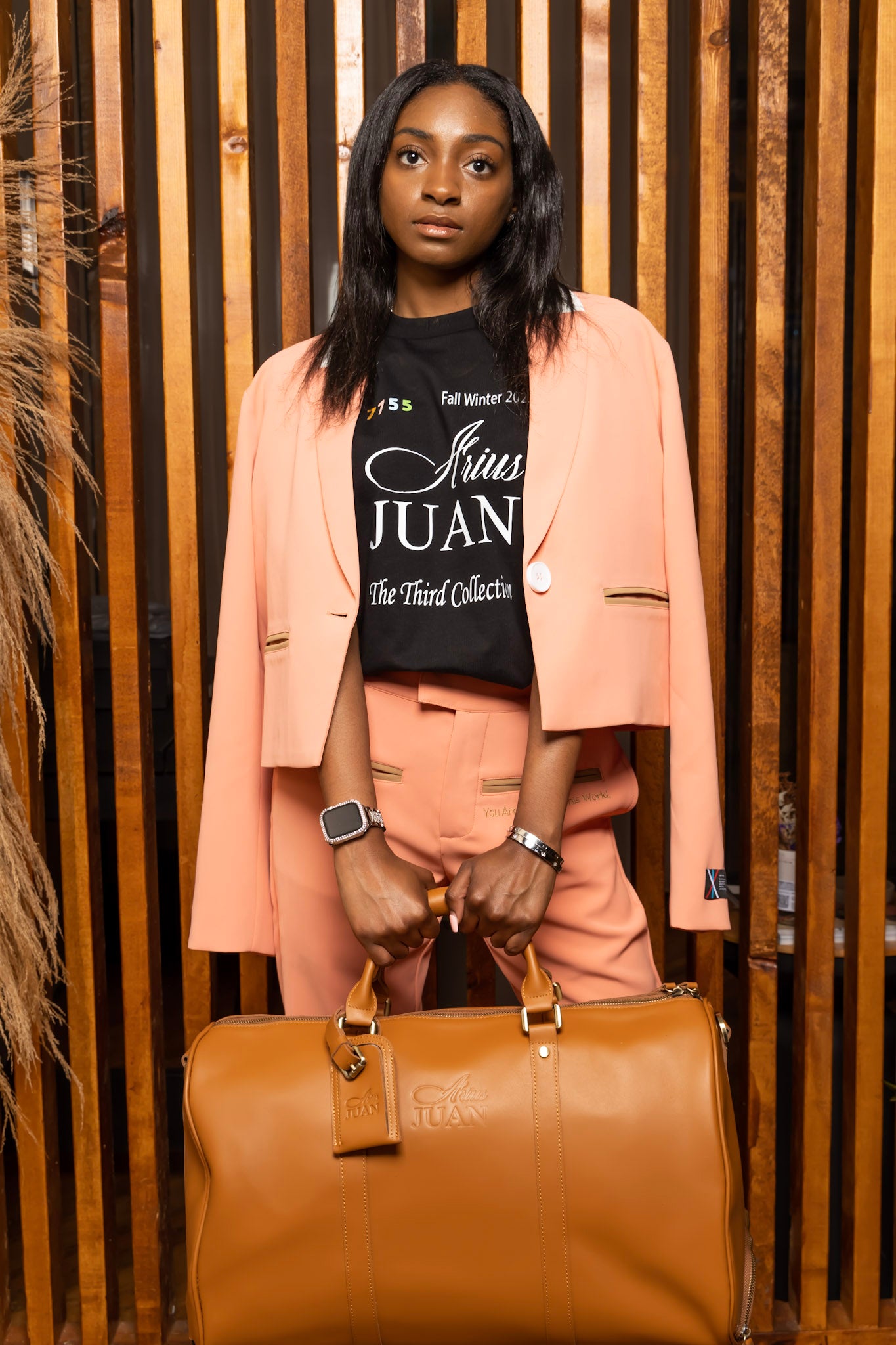 Model wearing Nature's Gift Cropped Blazer: Salmon Pink, Nature's Gift Salmon Pink Pants, The Classic Duffle Bag, The Third Collection T-Shirt: Black in a Arius Juan Campaign.