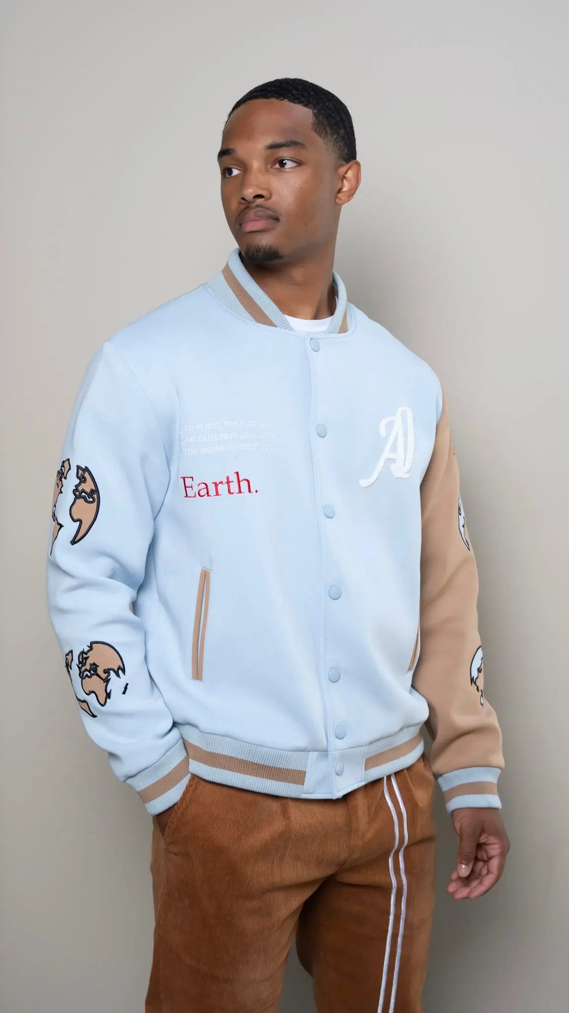 Photo of model in the Arius Juan Sky Blue Worldly Letterman Jacket posing for product picture.