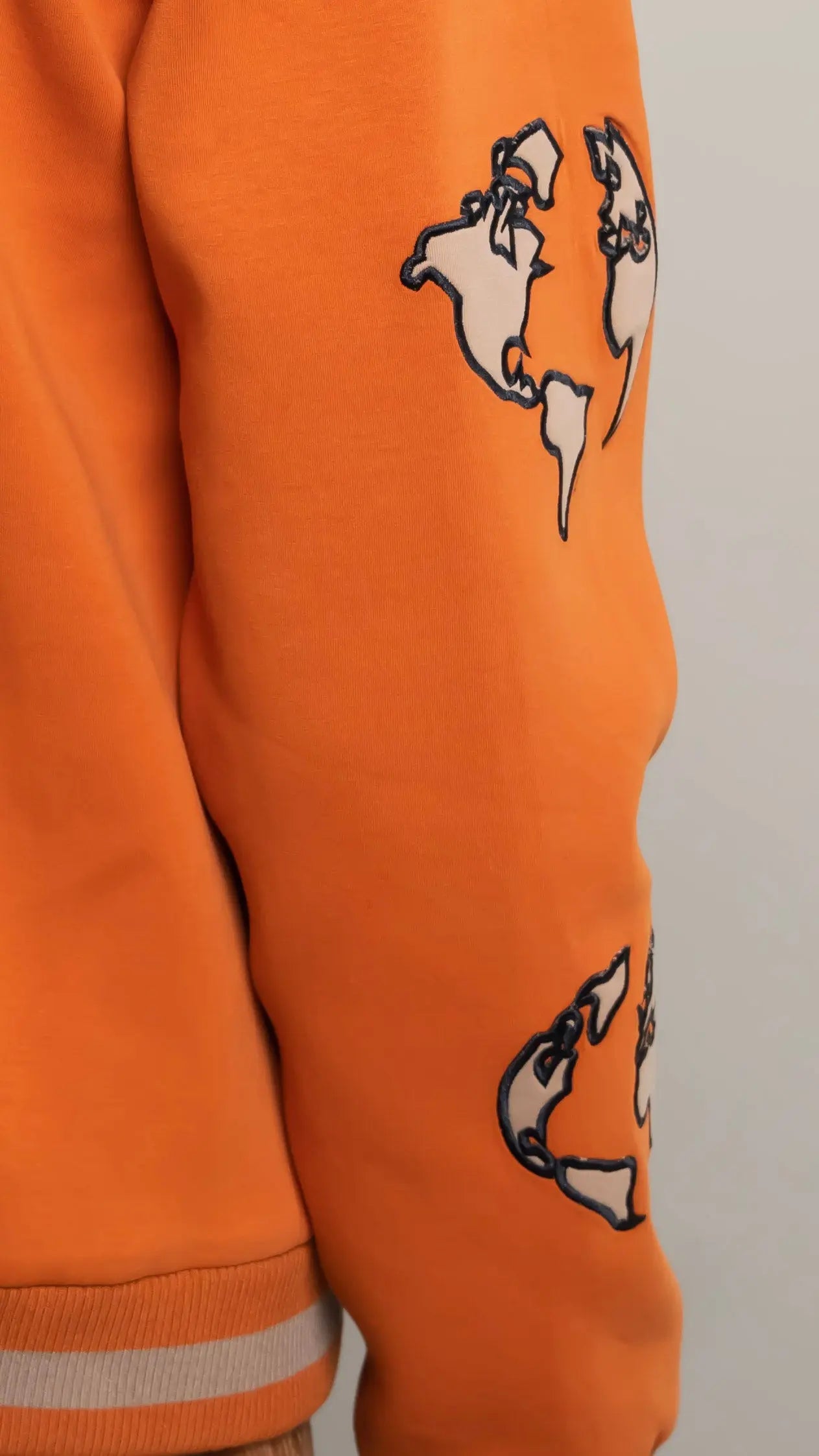 Photo of model in the Arius Juan Burnt Orange Worldly Letterman Jacket posing for product picture.