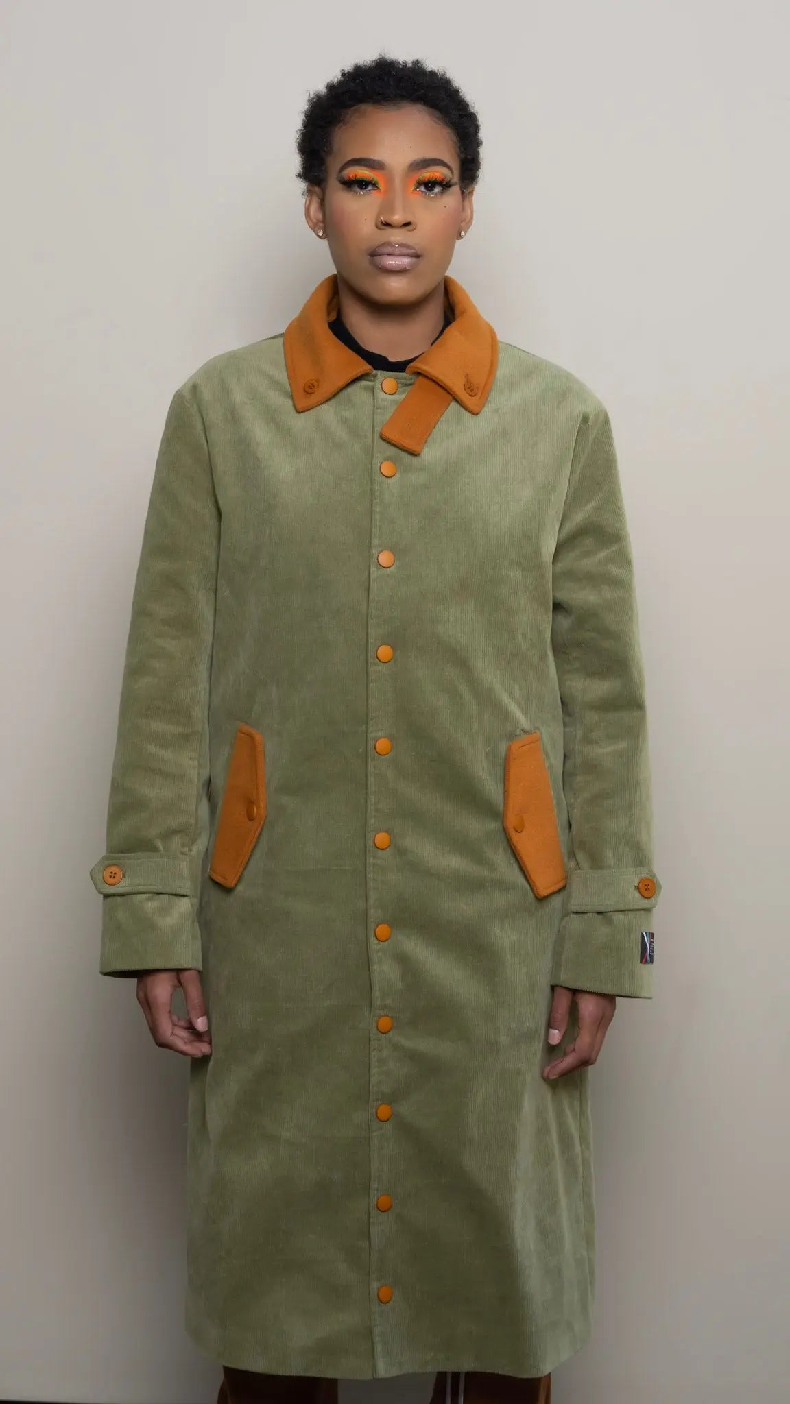 Photo of model in the Arius Juan Olive Green Earthly Trench Coat posing for product picture.
