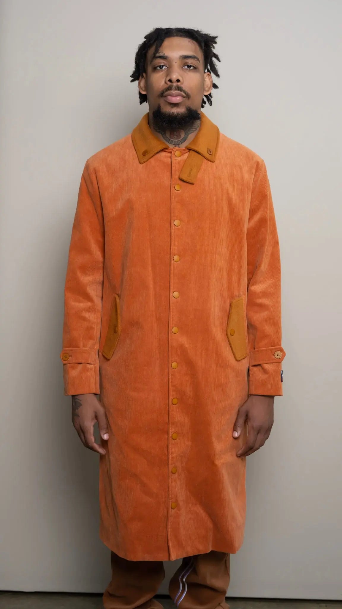 Photo of model in the Arius Juan Burnt Orange Earthly Trench Coat posing for product picture.