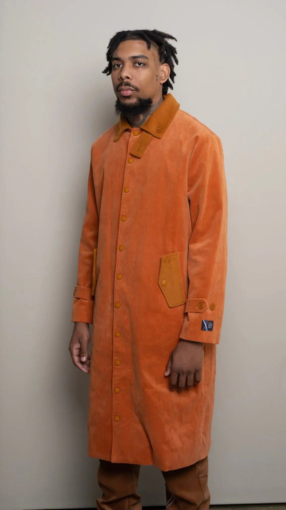 Photo of model in the Arius Juan Burnt Orange Earthly Trench Coat posing for product picture.