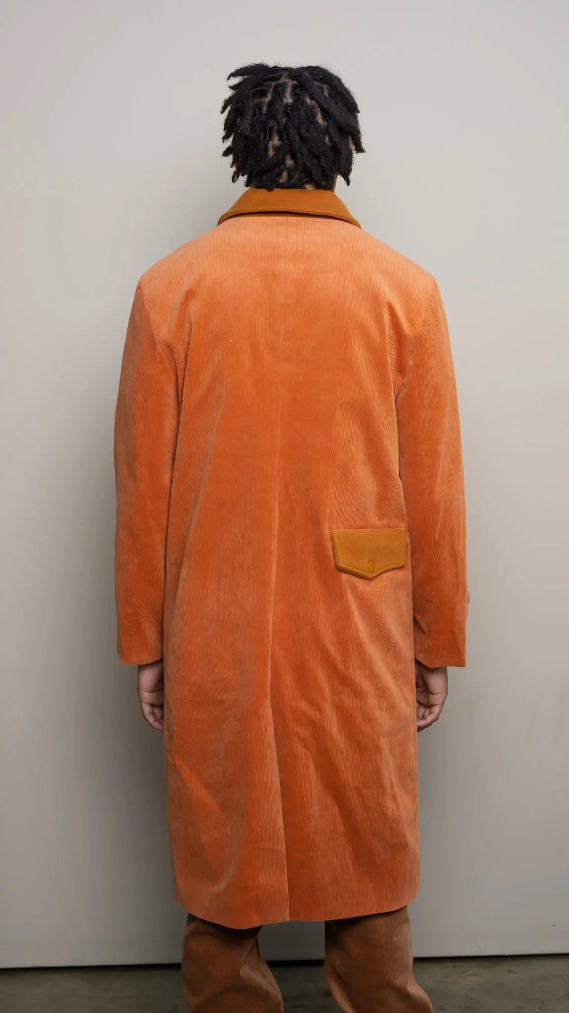 Photo of model in the Arius Juan Burnt Orange Earthly Trench Coat posing for product picture.
