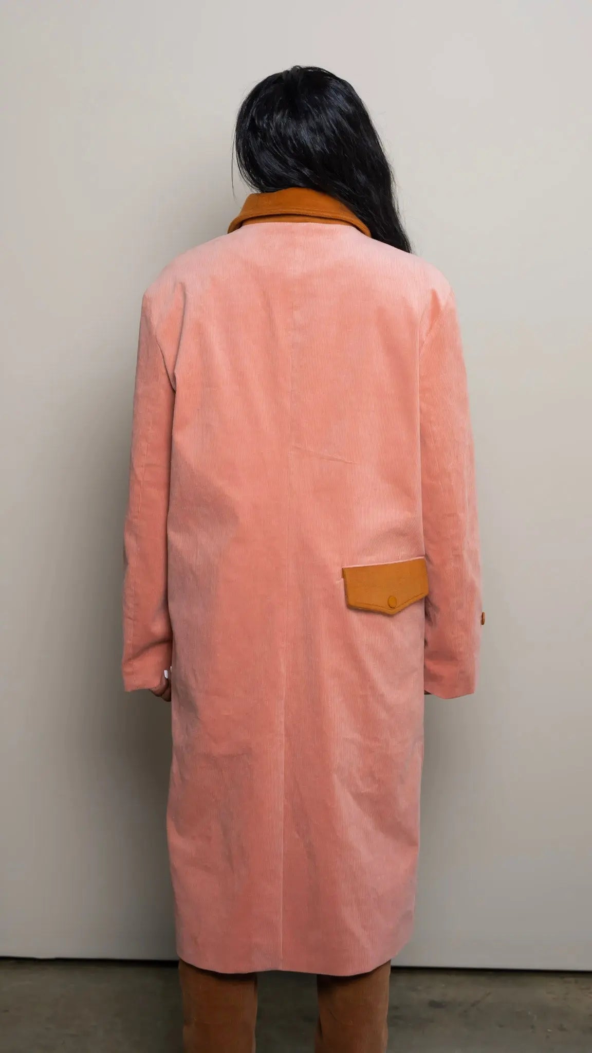 Photo of model in the Arius Juan Salmon Pink Earthly Trench Coat posing for product picture.